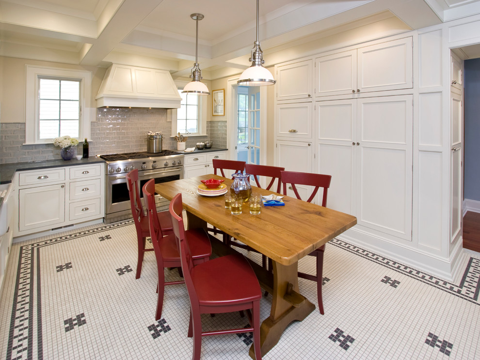 Example of a mid-sized classic u-shaped ceramic tile eat-in kitchen design in New York with a farmhouse sink, beaded inset cabinets, yellow cabinets, soapstone countertops, green backsplash, cement tile backsplash, stainless steel appliances and a peninsula