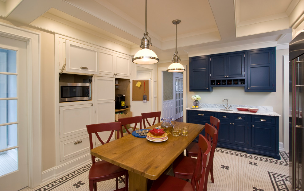 Inredning av ett klassiskt mellanstort kök, med en undermonterad diskho, luckor med profilerade fronter, blå skåp, marmorbänkskiva, vitt stänkskydd, stänkskydd i stenkakel, integrerade vitvaror och klinkergolv i keramik