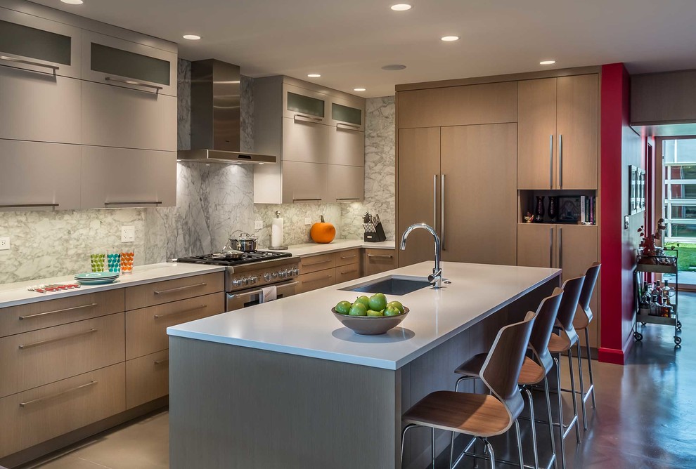 Medium sized contemporary l-shaped open plan kitchen in Chicago with a submerged sink, flat-panel cabinets, brown cabinets, recycled glass countertops, grey splashback, stone slab splashback, integrated appliances, concrete flooring and an island.