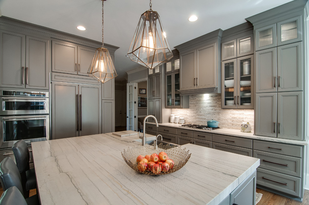 Large transitional single-wall light wood floor and brown floor eat-in kitchen photo in Charlotte with a single-bowl sink, recessed-panel cabinets, gray cabinets, limestone countertops, multicolored backsplash, marble backsplash, stainless steel appliances, an island and multicolored countertops