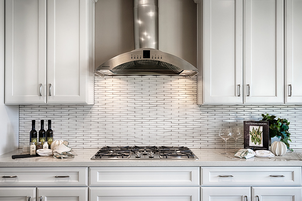 Example of a trendy l-shaped ceramic tile open concept kitchen design in Denver with an undermount sink, recessed-panel cabinets, white cabinets, quartz countertops, white backsplash, porcelain backsplash, stainless steel appliances and an island