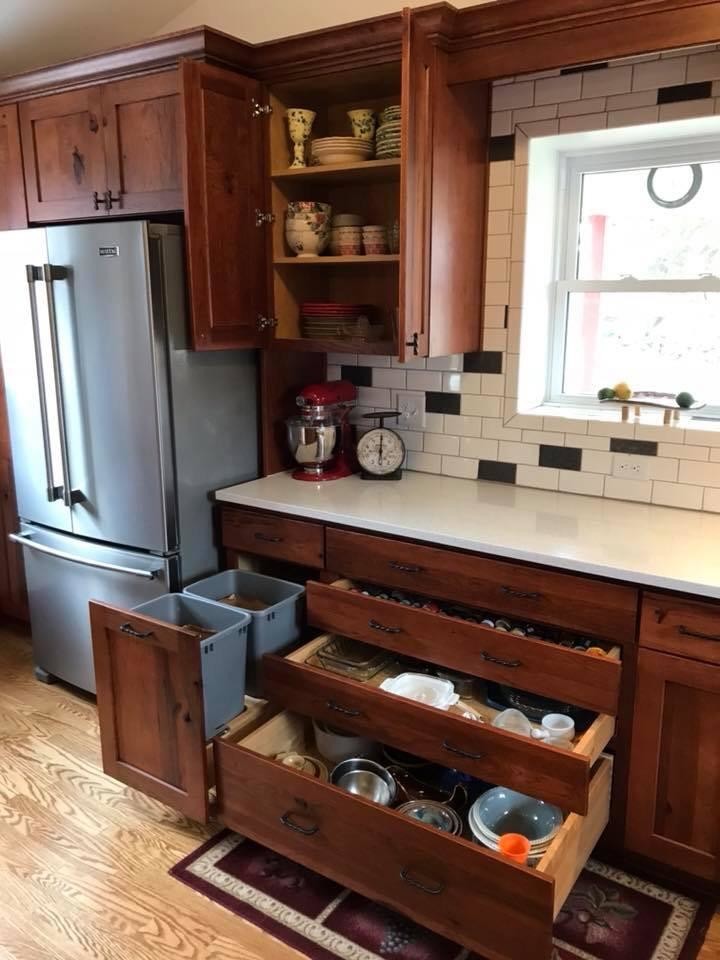 Design ideas for a mid-sized country l-shaped eat-in kitchen in Detroit with an undermount sink, shaker cabinets, red cabinets, quartz benchtops, white splashback, ceramic splashback, stainless steel appliances, light hardwood floors, a peninsula, yellow floor and white benchtop.