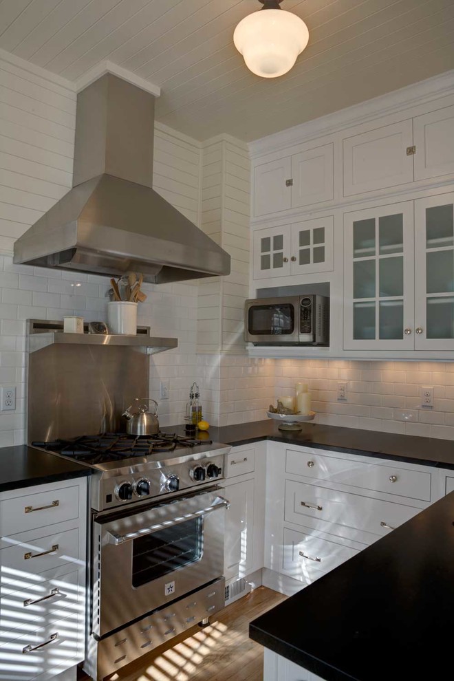 Exempel på ett litet modernt kök, med rostfria vitvaror, en enkel diskho, luckor med infälld panel, vita skåp, bänkskiva i koppar, vitt stänkskydd, stänkskydd i keramik och ljust trägolv