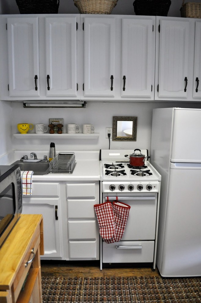 Modelo de cocina romántica pequeña sin isla con puertas de armario blancas, encimera de laminado y electrodomésticos blancos