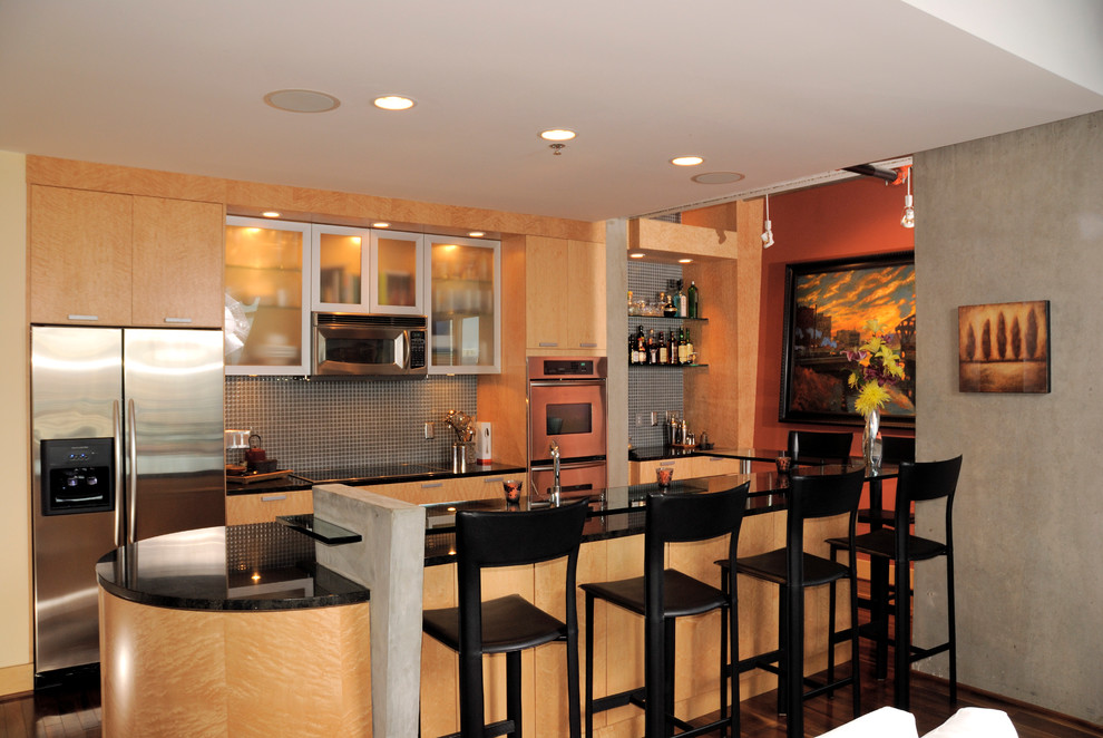 Example of a mid-sized trendy galley dark wood floor open concept kitchen design in Minneapolis with an undermount sink, flat-panel cabinets, light wood cabinets, granite countertops, metallic backsplash and stainless steel appliances