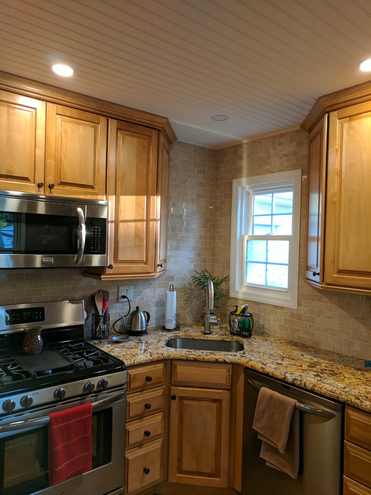 Immagine di una piccola cucina a L stile americano chiusa con lavello a vasca singola, ante in legno chiaro, top in granito, paraspruzzi beige, elettrodomestici in acciaio inossidabile e nessuna isola