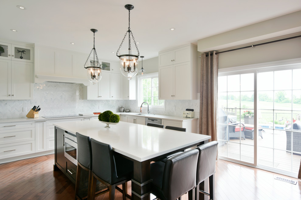 Eat-in kitchen - large contemporary u-shaped medium tone wood floor eat-in kitchen idea in Ottawa with an undermount sink, shaker cabinets, white cabinets, quartz countertops, white backsplash, stone tile backsplash, stainless steel appliances and an island