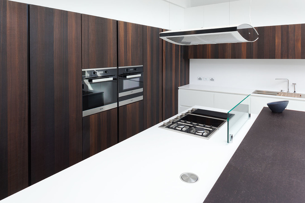 Esempio di una grande cucina design con top in quarzo composito, paraspruzzi bianco, elettrodomestici in acciaio inossidabile e pavimento in cemento