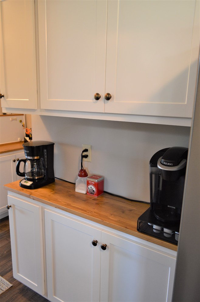 Foto på ett avskilt, mellanstort vintage brun u-kök, med skåp i shakerstil, vita skåp, träbänkskiva, en halv köksö och brunt golv