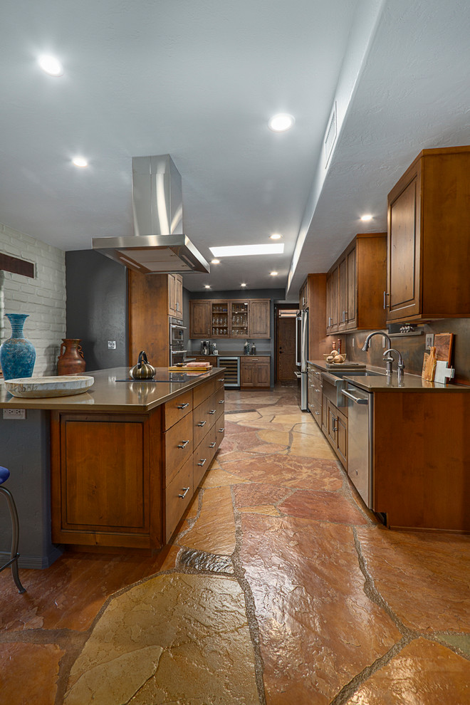 Example of a large southwest u-shaped slate floor and brown floor enclosed kitchen design in Phoenix with a farmhouse sink, raised-panel cabinets, medium tone wood cabinets, quartz countertops, metallic backsplash, metal backsplash, stainless steel appliances, a peninsula and brown countertops
