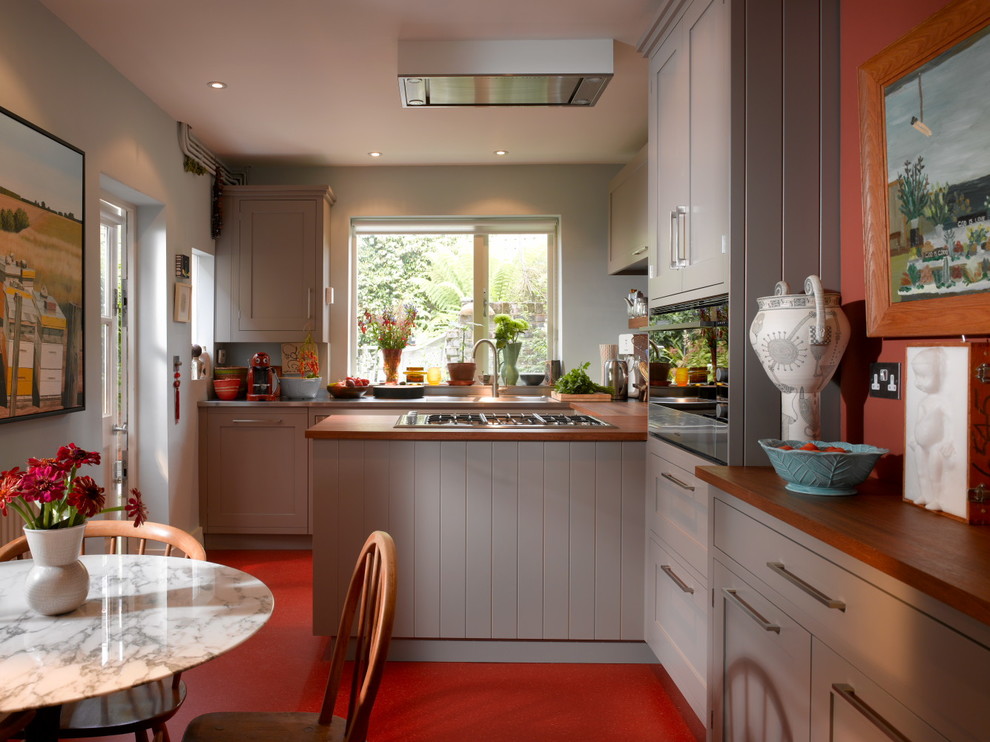 Inspiration för ett litet funkis kök och matrum, med luckor med infälld panel, grå skåp, bänkskiva i rostfritt stål, glaspanel som stänkskydd och rött golv