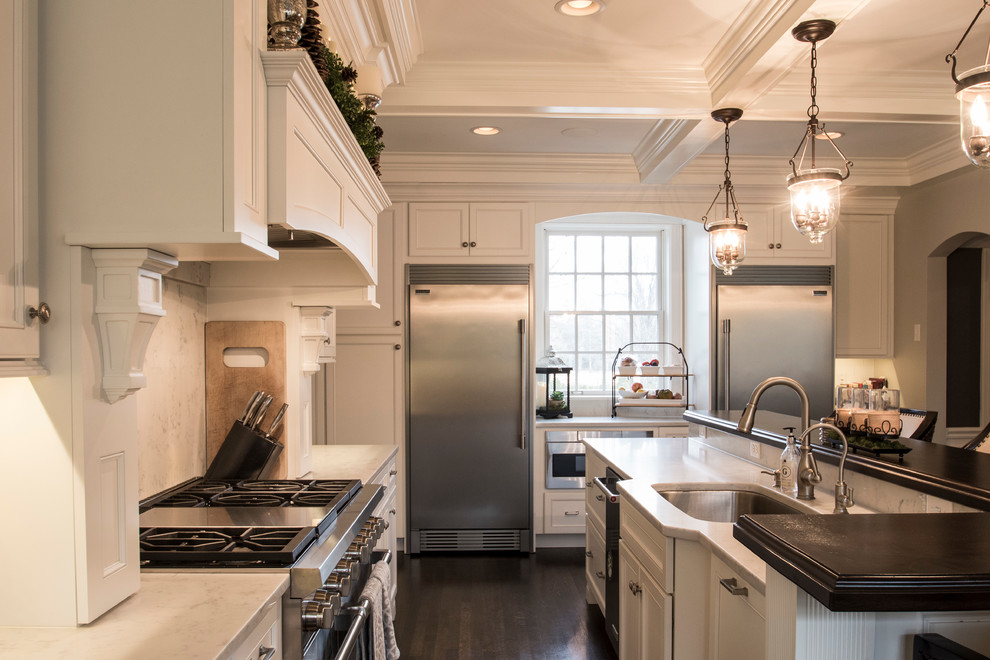 Large elegant l-shaped dark wood floor and brown floor eat-in kitchen photo in Other with an undermount sink, recessed-panel cabinets, white cabinets, marble countertops, white backsplash, subway tile backsplash, stainless steel appliances and an island