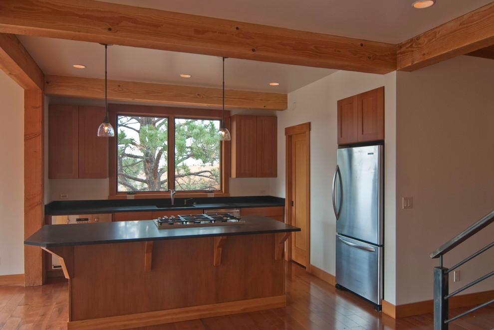 Small mountain style l-shaped medium tone wood floor open concept kitchen photo in Denver with a single-bowl sink, recessed-panel cabinets, medium tone wood cabinets, granite countertops, beige backsplash, stone slab backsplash, stainless steel appliances and an island