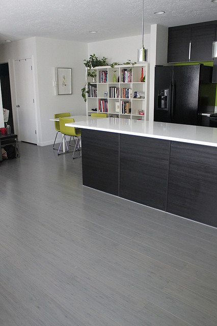 Idee per una cucina design con ante nere, top in quarzo composito e pavimento in bambù