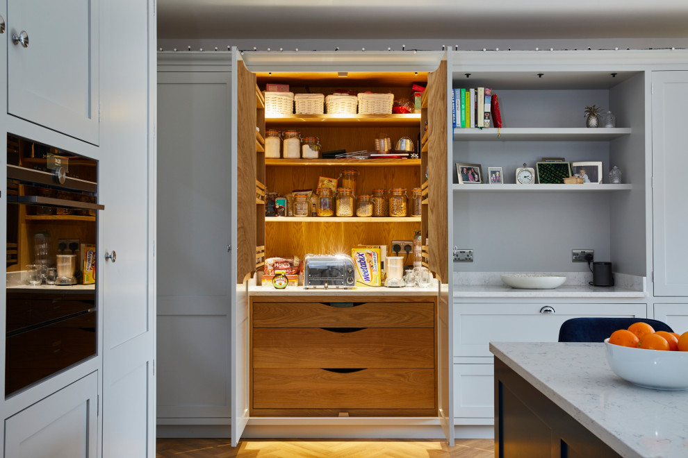 Photo of a large contemporary u-shaped open plan kitchen in Kent with a double-bowl sink, an island and white worktops.