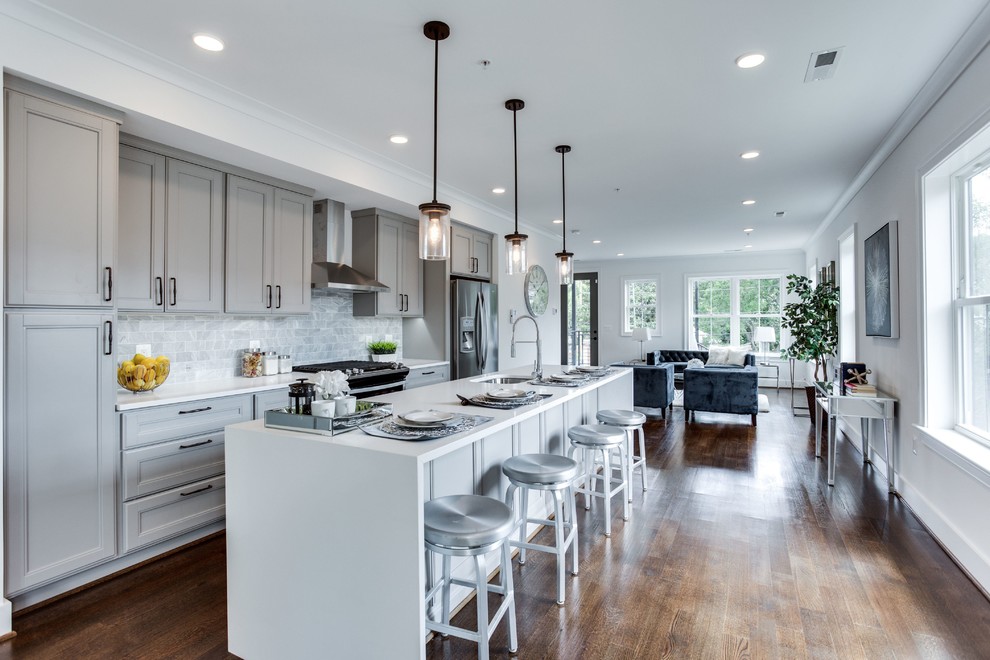 Mid-sized transitional galley dark wood floor and brown floor open concept kitchen photo in DC Metro with an undermount sink, recessed-panel cabinets, gray cabinets, quartz countertops, gray backsplash, marble backsplash, stainless steel appliances, an island and white countertops