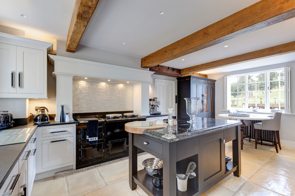 Example of a mid-sized farmhouse l-shaped limestone floor and beige floor eat-in kitchen design in Cheshire with shaker cabinets, granite countertops, white backsplash, black appliances, white cabinets and an island