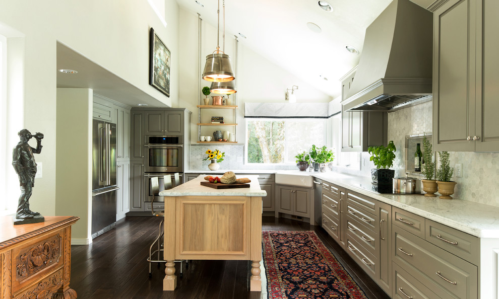 Inspiration for a large traditional l-shaped kitchen/diner in Portland with recessed-panel cabinets, light wood cabinets, an island, a belfast sink, marble worktops, white splashback, stone tiled splashback, stainless steel appliances and dark hardwood flooring.