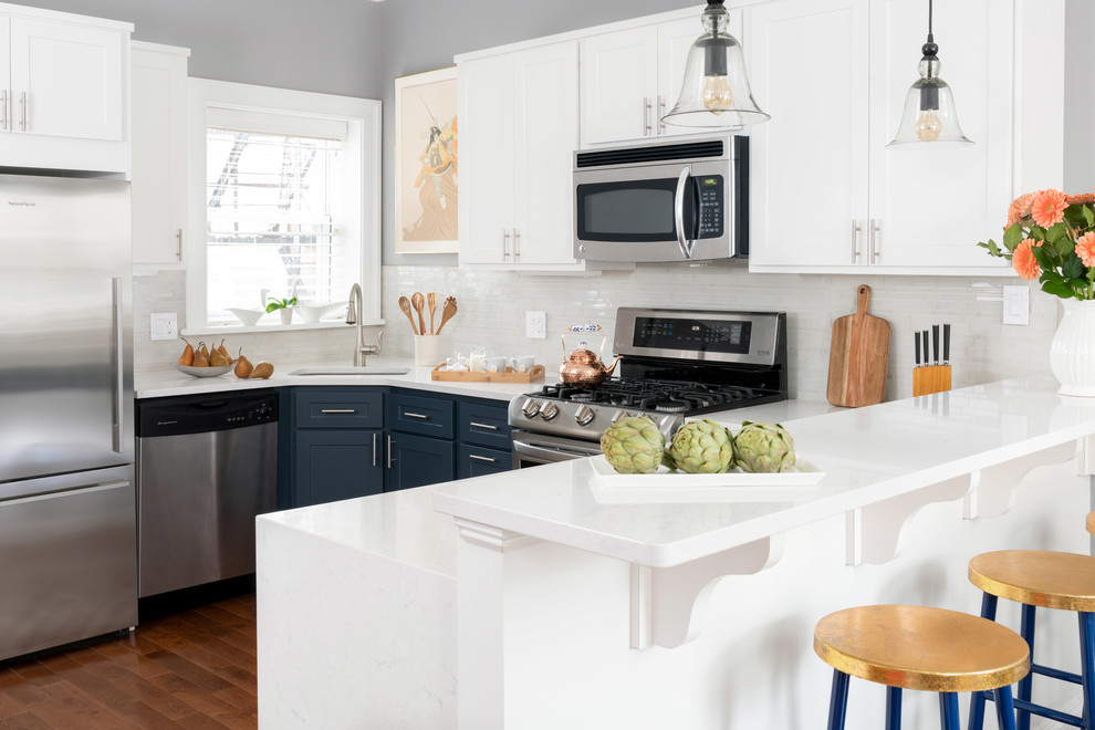 Mid-sized trendy u-shaped dark wood floor and brown floor eat-in kitchen photo in Philadelphia with a single-bowl sink, flat-panel cabinets, blue cabinets, quartzite countertops, white backsplash, ceramic backsplash, stainless steel appliances and white countertops
