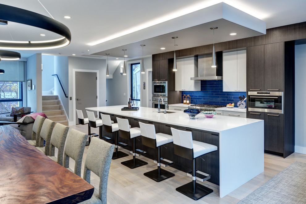 Design ideas for a large contemporary galley kitchen in New York with flat-panel cabinets, medium wood cabinets, blue splashback, an island, white worktops, a submerged sink, stainless steel appliances and green floors.
