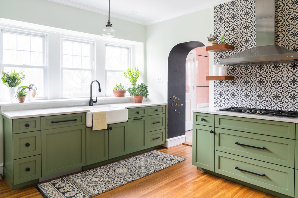 Foto på ett stort funkis vit kök, med en rustik diskho, skåp i shakerstil, gröna skåp, bänkskiva i kvarts, vitt stänkskydd, stänkskydd i cementkakel, rostfria vitvaror, ljust trägolv, en halv köksö och orange golv