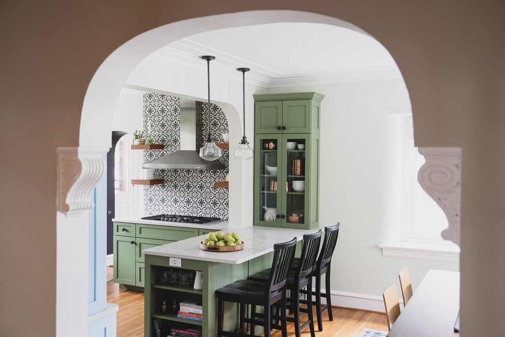 Inredning av ett modernt stort vit vitt kök, med en rustik diskho, skåp i shakerstil, gröna skåp, bänkskiva i kvarts, vitt stänkskydd, stänkskydd i cementkakel, rostfria vitvaror, ljust trägolv, en halv köksö och orange golv