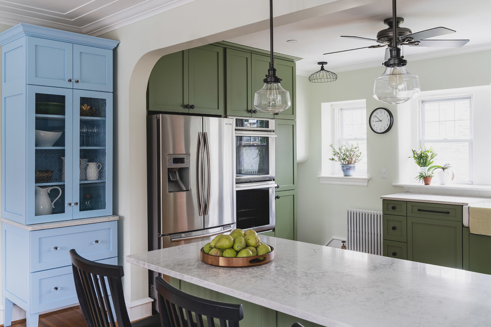 Inspiration for a large modern u-shaped light wood floor and orange floor eat-in kitchen remodel in Philadelphia with a farmhouse sink, shaker cabinets, green cabinets, quartz countertops, white backsplash, cement tile backsplash, stainless steel appliances, a peninsula and white countertops