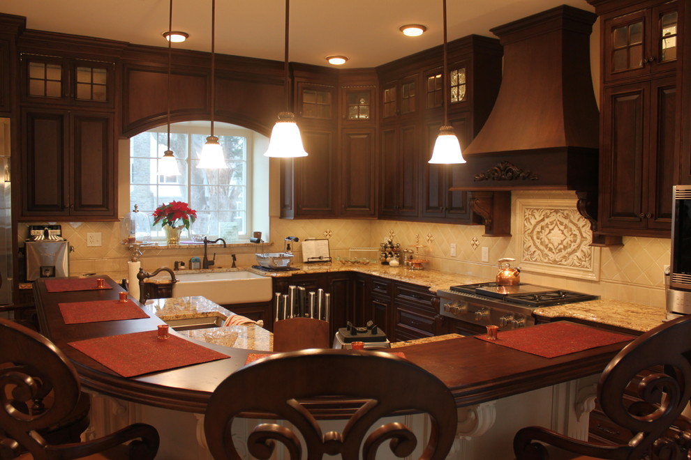 Bild på ett stort vintage kök, med en rustik diskho, luckor med profilerade fronter, skåp i mörkt trä, granitbänkskiva, beige stänkskydd, stänkskydd i porslinskakel, rostfria vitvaror, klinkergolv i porslin och en köksö