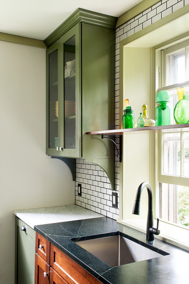 Bild på ett mellanstort vintage u-kök, med en undermonterad diskho, luckor med infälld panel, skåp i mellenmörkt trä, vitt stänkskydd, rostfria vitvaror, en köksö, bänkskiva i täljsten, stänkskydd i tunnelbanekakel, klinkergolv i keramik och grått golv