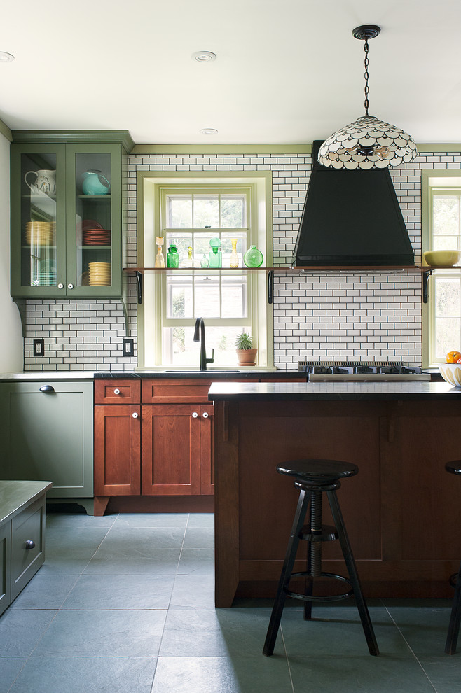 Inspiration for a mid-sized eclectic u-shaped ceramic tile and gray floor enclosed kitchen remodel in Philadelphia with an undermount sink, recessed-panel cabinets, medium tone wood cabinets, white backsplash, stainless steel appliances, an island, soapstone countertops and subway tile backsplash