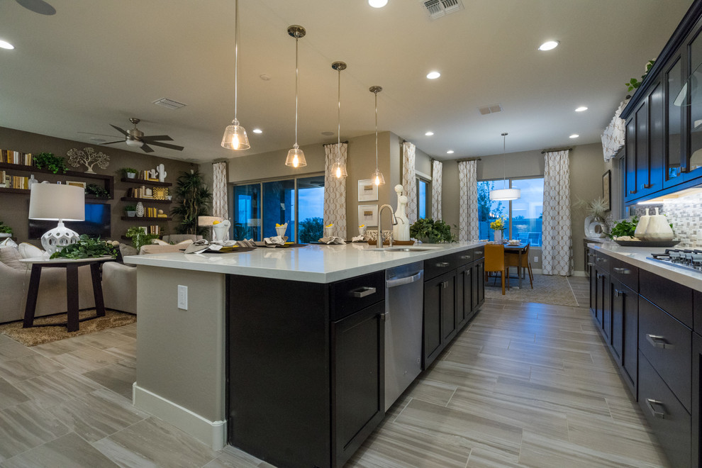 Large trendy l-shaped porcelain tile and beige floor eat-in kitchen photo in Phoenix with a farmhouse sink, recessed-panel cabinets, dark wood cabinets, solid surface countertops, beige backsplash, glass sheet backsplash, stainless steel appliances and an island
