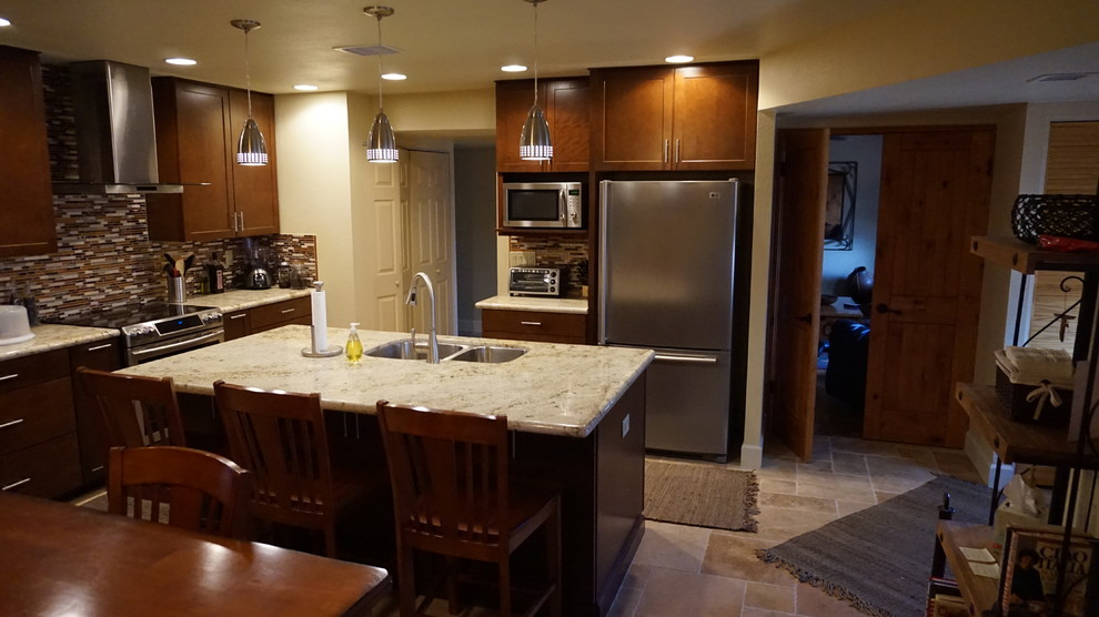 Modern inredning av ett mellanstort kök, med en undermonterad diskho, skåp i shakerstil, skåp i mellenmörkt trä, granitbänkskiva, flerfärgad stänkskydd, stänkskydd i mosaik, rostfria vitvaror, travertin golv och en köksö