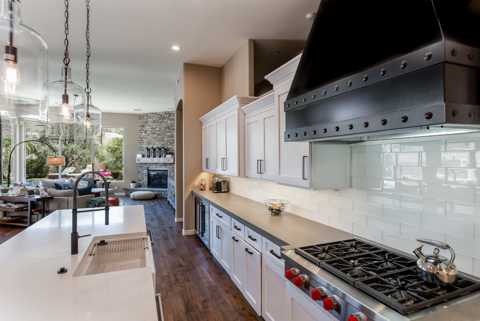 Moderne Küche mit Landhausspüle, Schrankfronten im Shaker-Stil, weißen Schränken, Kücheninsel und braunem Boden in Phoenix