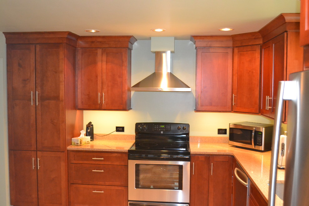 Foto di una cucina classica di medie dimensioni con lavello sottopiano, ante in stile shaker, ante in legno chiaro, top in quarzite, paraspruzzi beige, elettrodomestici in acciaio inossidabile e pavimento in laminato