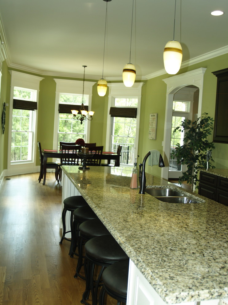 Example of a classic medium tone wood floor eat-in kitchen design in Nashville with an undermount sink and an island