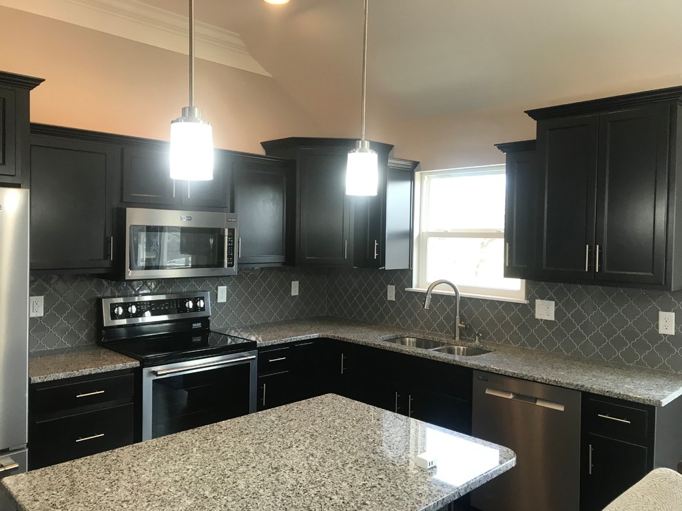 Eat-in kitchen - mid-sized transitional l-shaped eat-in kitchen idea in Louisville with a double-bowl sink, recessed-panel cabinets, black cabinets, granite countertops, gray backsplash, ceramic backsplash, black appliances, an island and gray countertops