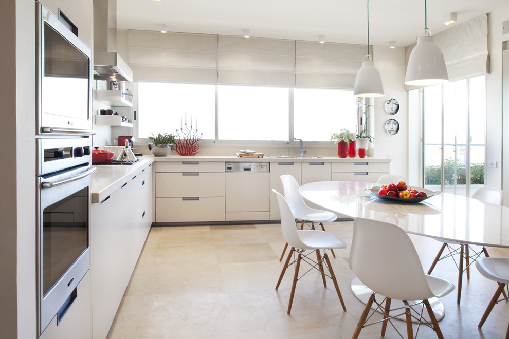 Example of a minimalist eat-in kitchen design in Tel Aviv with paneled appliances, flat-panel cabinets and white cabinets