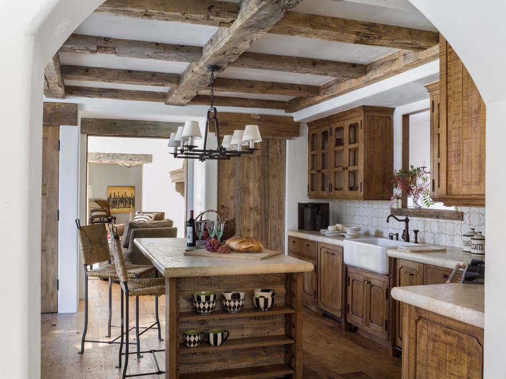 Immagine di una cucina rustica con lavello stile country, ante in legno scuro, paraspruzzi bianco e pavimento in legno massello medio