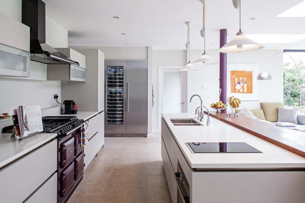 Trendy galley open concept kitchen photo in London with a double-bowl sink, flat-panel cabinets, gray cabinets, colored appliances and an island
