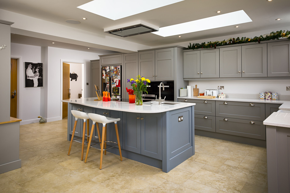 Inspiration for a transitional l-shaped eat-in kitchen remodel in Oxfordshire with shaker cabinets, blue cabinets and an island
