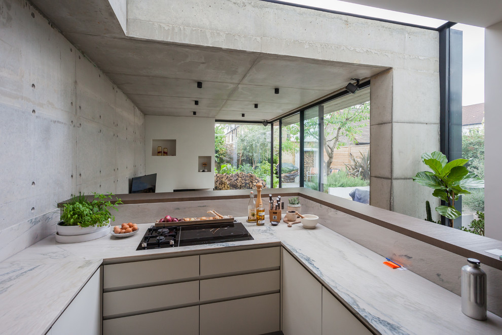 Cette photo montre une cuisine ouverte tendance en U de taille moyenne avec plan de travail en marbre, une crédence jaune, une crédence en marbre et îlot.
