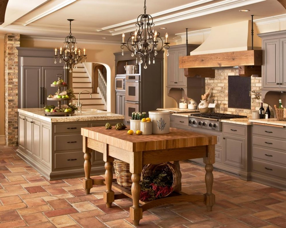 Exempel på ett avskilt, stort rustikt u-kök, med en rustik diskho, luckor med upphöjd panel, grå skåp, granitbänkskiva, beige stänkskydd, stänkskydd i tegel, integrerade vitvaror, travertin golv och flera köksöar