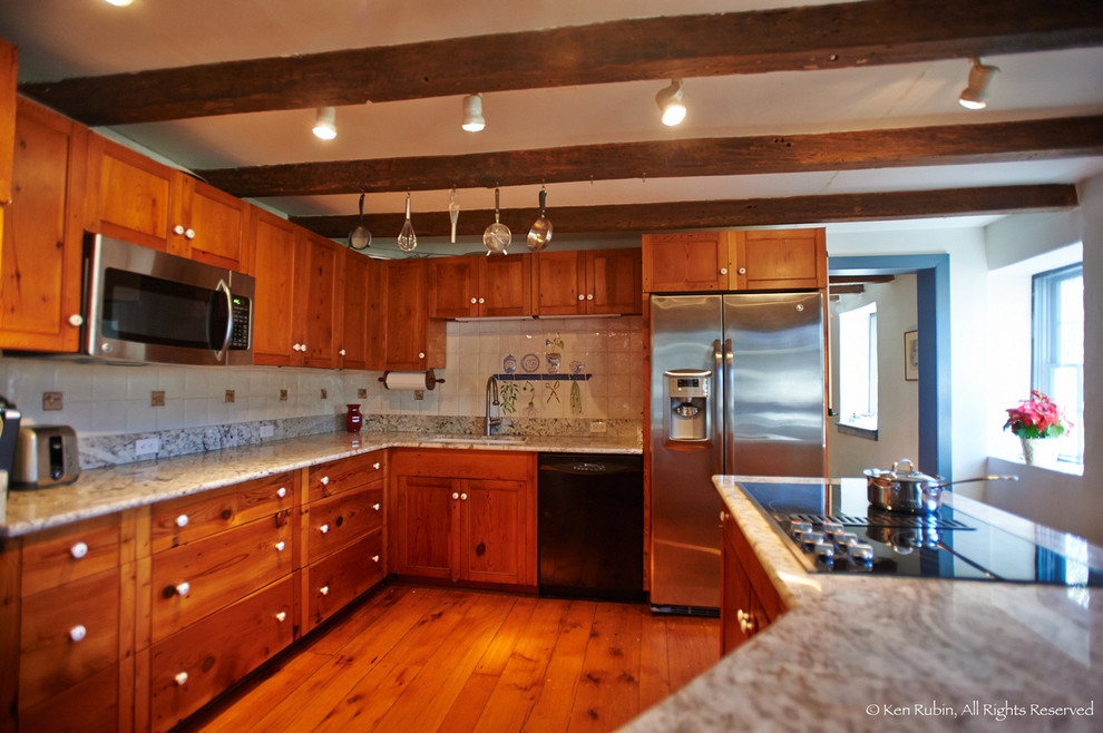 Inredning av ett lantligt mellanstort kök, med en undermonterad diskho, luckor med infälld panel, skåp i mellenmörkt trä, granitbänkskiva, beige stänkskydd, stänkskydd i keramik, rostfria vitvaror, en halv köksö och mellanmörkt trägolv