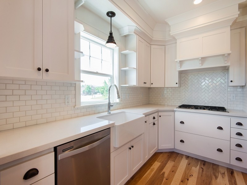 Large arts and crafts u-shaped light wood floor kitchen photo in Salt Lake City with a farmhouse sink, recessed-panel cabinets, white cabinets, white backsplash, ceramic backsplash and stainless steel appliances