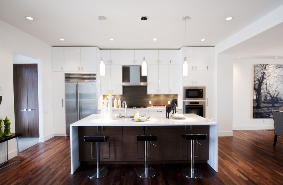 Foto de cocina comedor contemporánea con electrodomésticos de acero inoxidable, armarios con paneles lisos, puertas de armario blancas, encimera de cuarzo compacto y salpicadero verde
