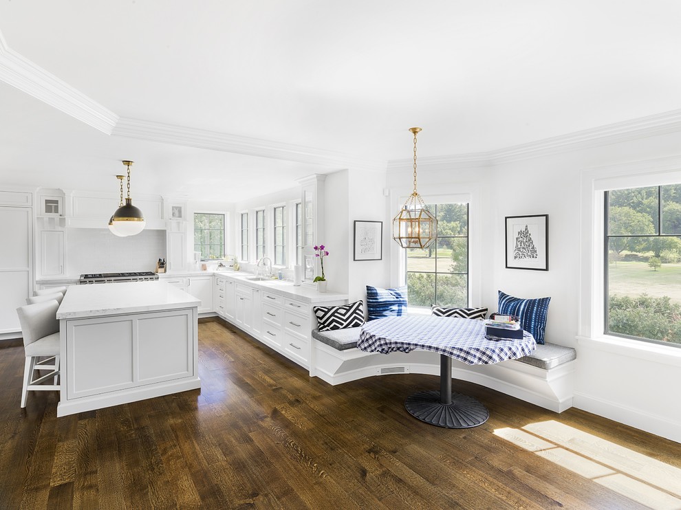 Klassische Wohnküche in L-Form mit Unterbauwaschbecken, Schrankfronten im Shaker-Stil, weißen Schränken, Küchenrückwand in Weiß, dunklem Holzboden, Kücheninsel und braunem Boden in Boston