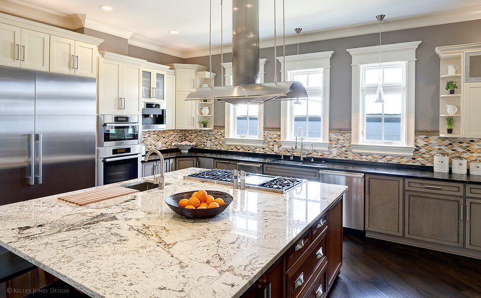Trendy l-shaped eat-in kitchen photo in Nashville with an undermount sink, raised-panel cabinets, gray cabinets, granite countertops, glass tile backsplash and stainless steel appliances