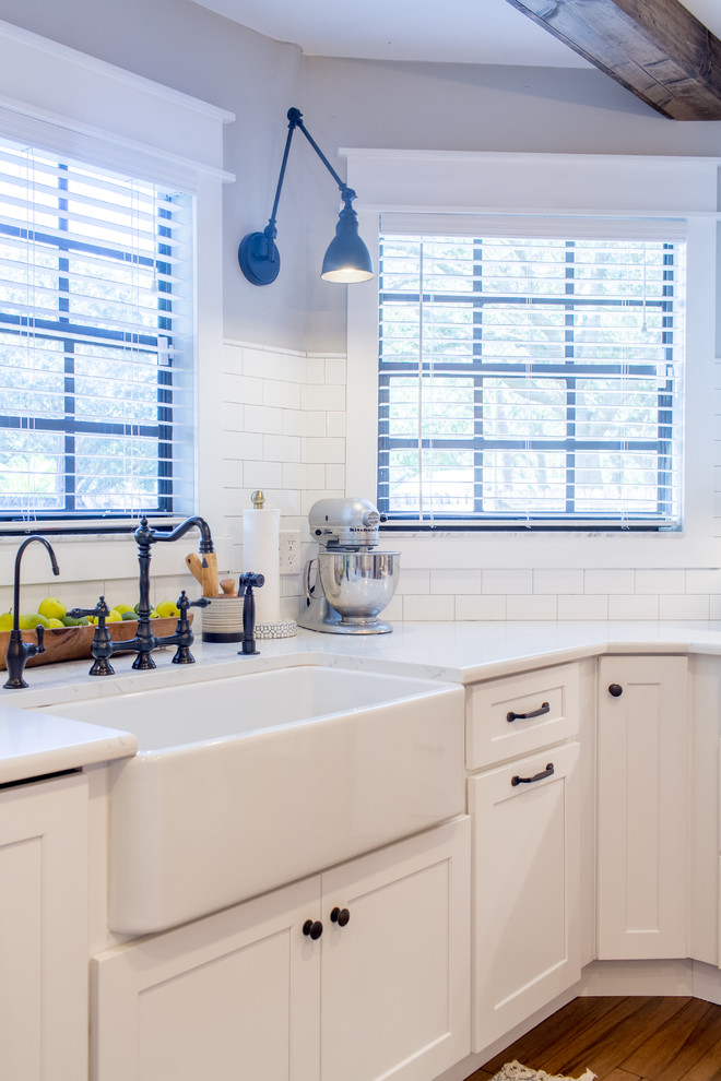 Bild på ett mellanstort lantligt brun brunt kök, med en rustik diskho, skåp i shakerstil, vita skåp, träbänkskiva, grått stänkskydd, stänkskydd i marmor, integrerade vitvaror, mellanmörkt trägolv, en köksö och brunt golv