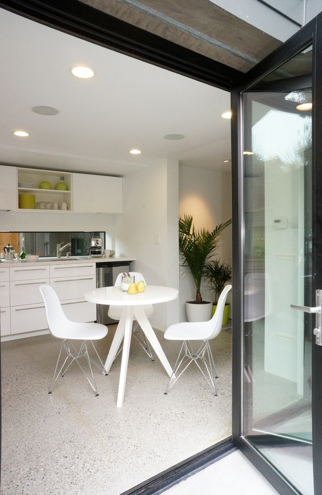 Minimalist single-wall eat-in kitchen photo in San Francisco with flat-panel cabinets and white cabinets