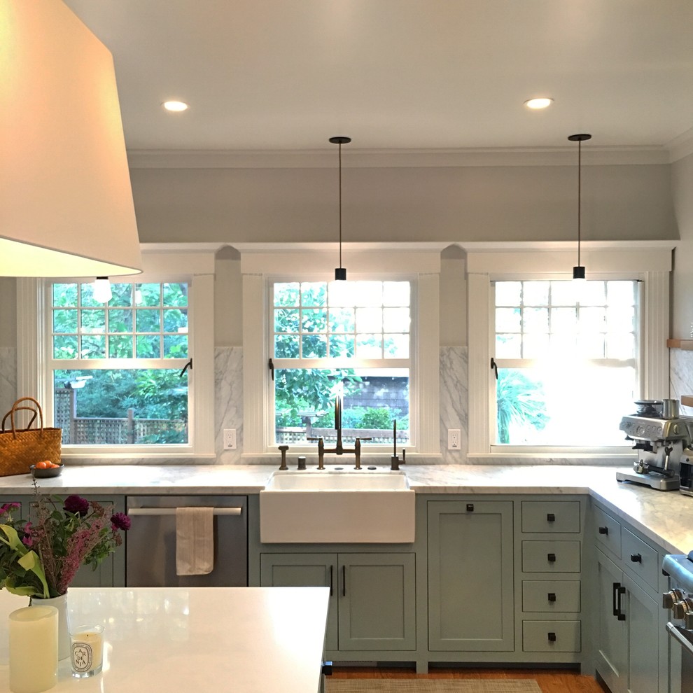 Inspiration for a mid-sized craftsman u-shaped light wood floor and brown floor eat-in kitchen remodel in San Francisco with a farmhouse sink, shaker cabinets, gray cabinets, marble countertops, white backsplash, marble backsplash, paneled appliances and an island
